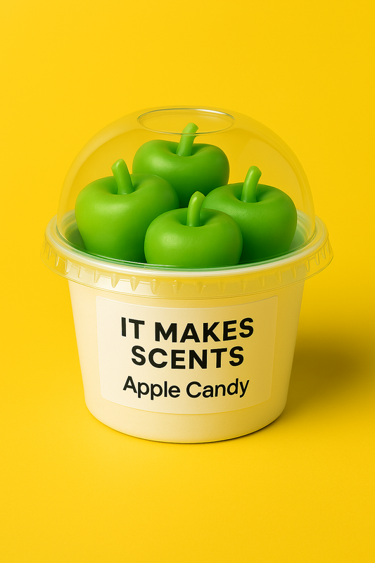 Apple-shaped green wax melts in a clear dome container labeled “It Makes Scents – Apple Candy,” set against a bright yellow background